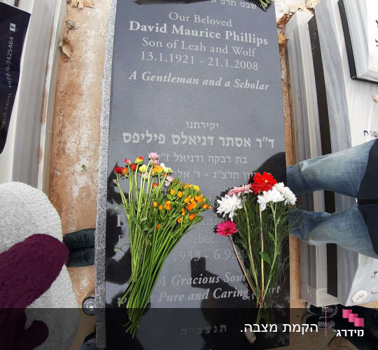 מצבות עם פרחים וכתובות בעברית ואנגלית